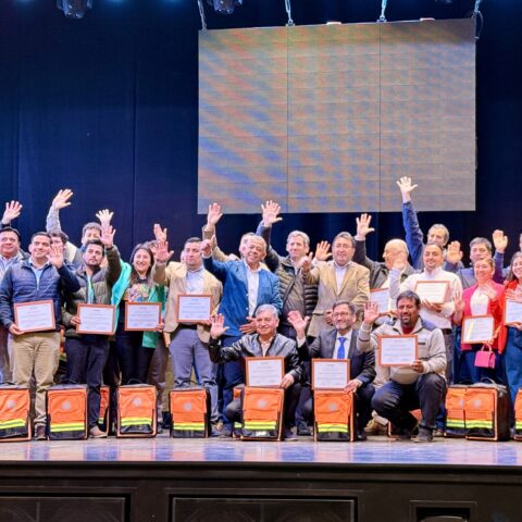 Tutoras comunitarias con diplomas en un escenario