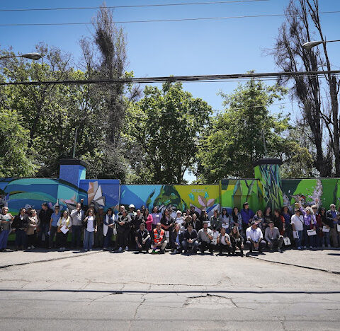 Voluntarios posan frente a un mural